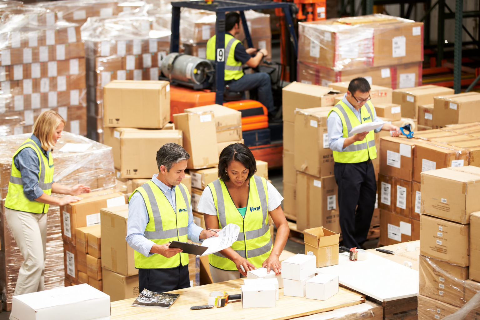 Verst Logistics warehouse crew in reflective safety vests packing and labeling orders